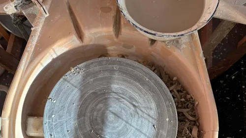 Potter's wheel with clay and water bowl.