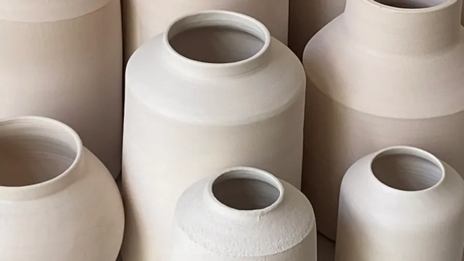 Clay vases grouped together in soft light.