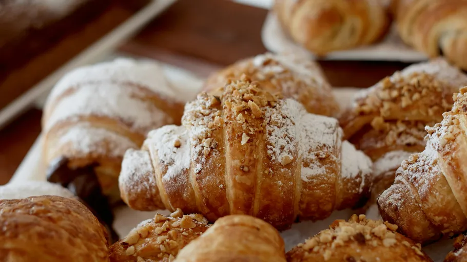 Croissants auf einem Holztisch, mit Zucker bestreut.