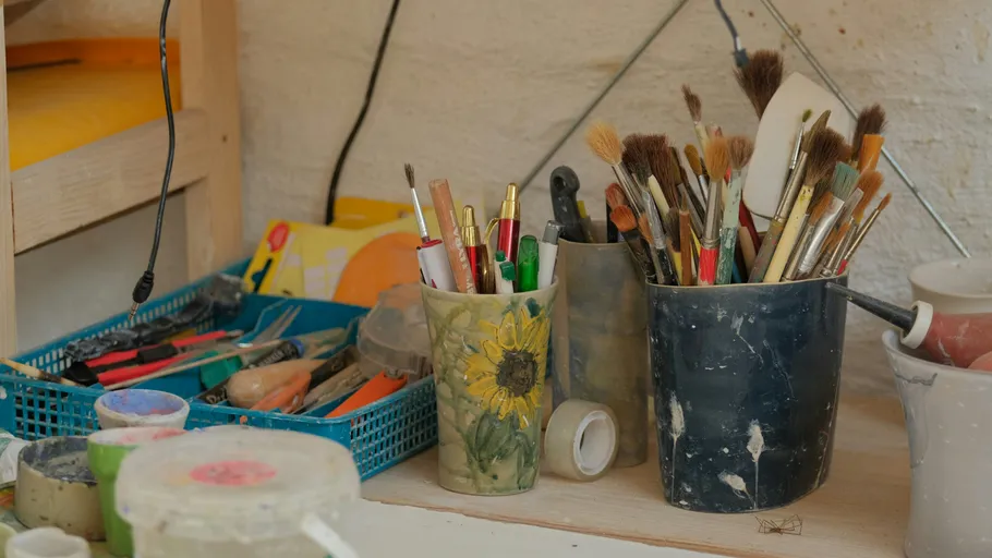 Paintbrushes and tools on an artist's workspace.