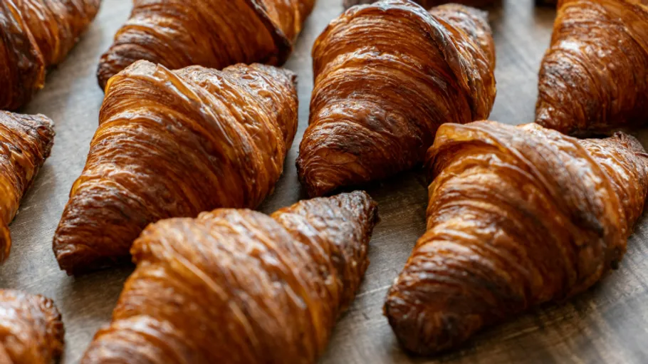 Croissants arranged on wooden surface.