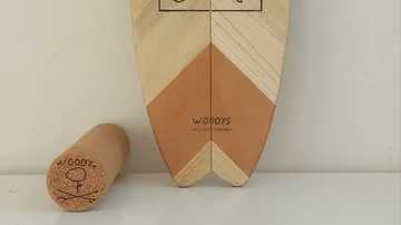 Holz-Balanceboard und Rolle auf weißer Fläche.