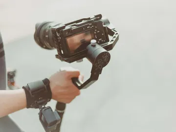 The camera is held in the hand with a holder.