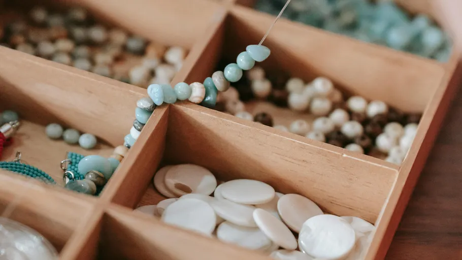 Assorted beads in a wooden organizer box.