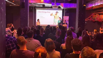 People watching a presentation in a dimly lit room.