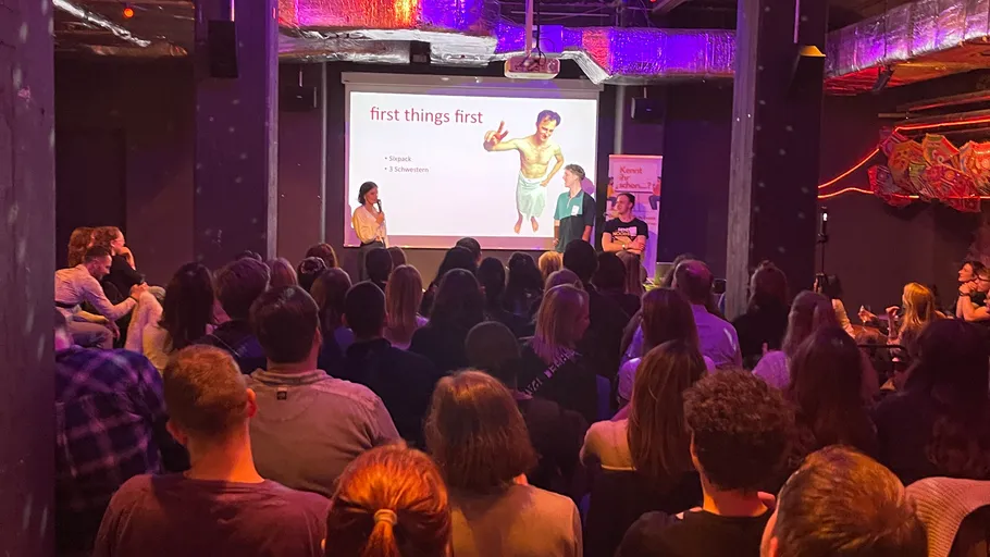 People watching a presentation in a dimly lit room.