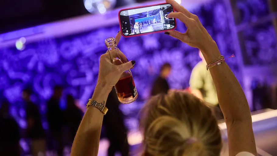 Person photographing with smartphone at event.