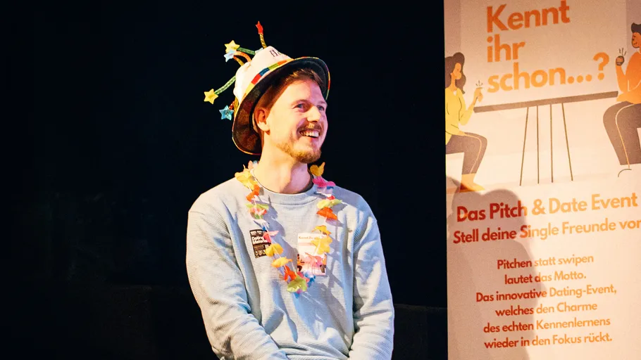 Man wearing hat and lei at dating event.