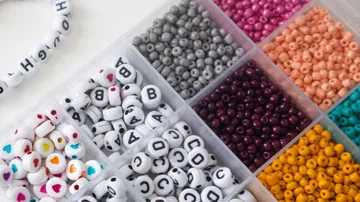 Bunte Perlen in Kunststoffbehälter sortiert.