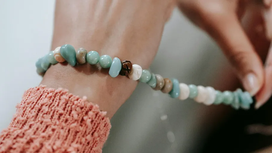 Armband mit bunten Steinen am Handgelenk.