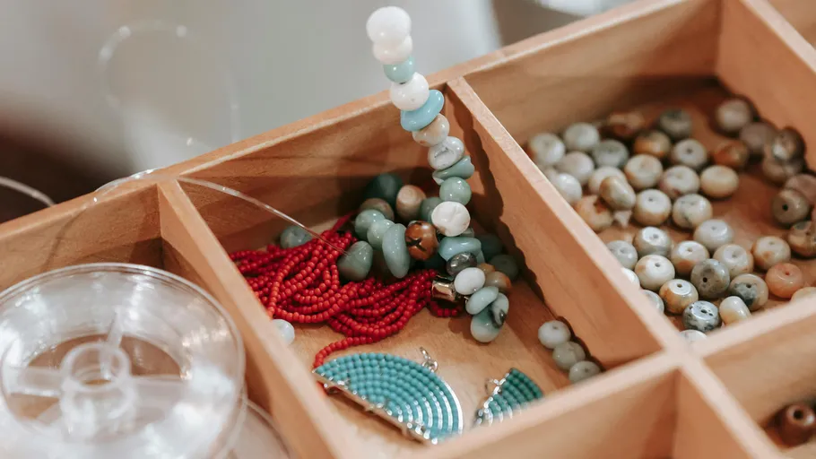 Wooden box with colorful beads inside.
