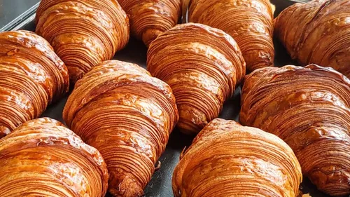 Freshly baked croissants on a baking tray.
