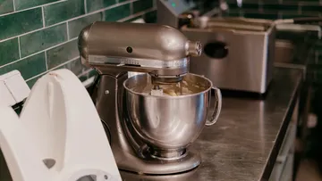 Mixer mischt Zutaten in einer Küche.