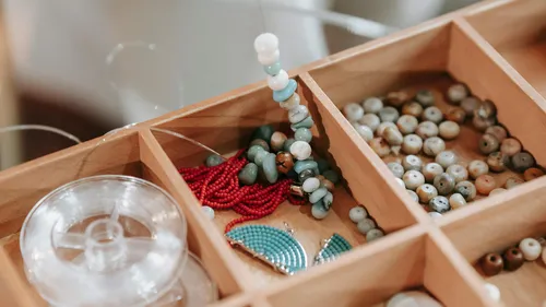 Craft beads neatly organized in a wooden box.