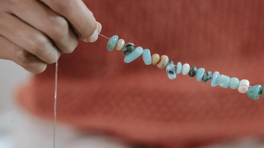 Hand holding a string of colorful beads.