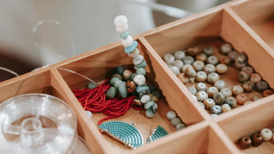 Assorted beads in a wooden organizer.