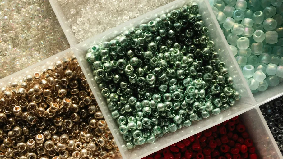 Assorted beads sorted by color in a box.