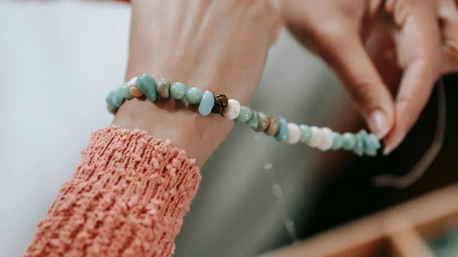 Person holding beaded bracelet in hands.