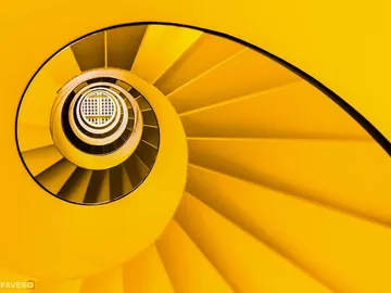 Gelbe Wendeltreppe dreht sich nach oben in einem Turm.