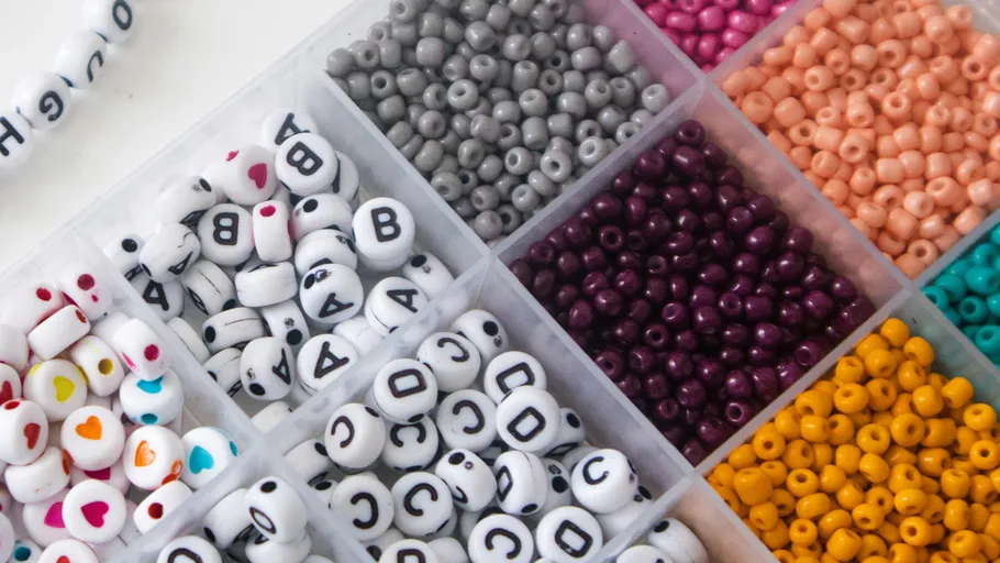 Assorted beads organized in plastic container.