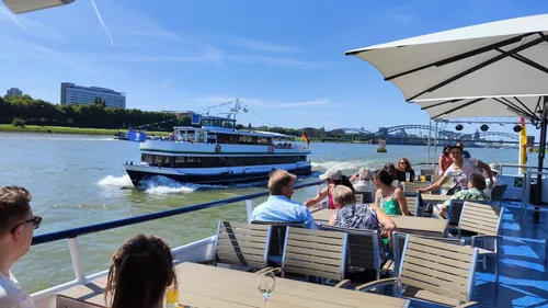 Menschen entspannen auf einem Flussboot unter Schirm.