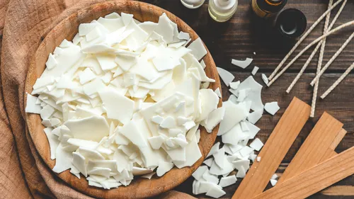 Soy wax flakes in bowl with candle supplies.