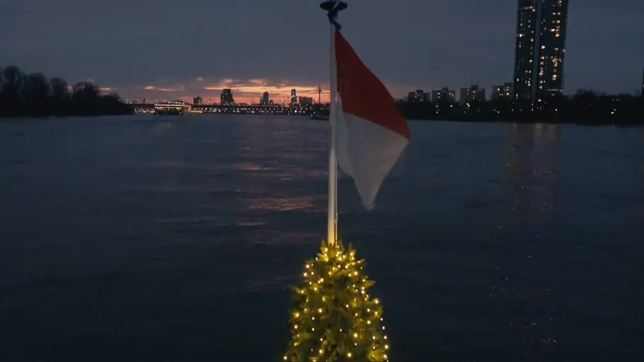 Niederländische Flagge auf Boot, Stadt am Abend.