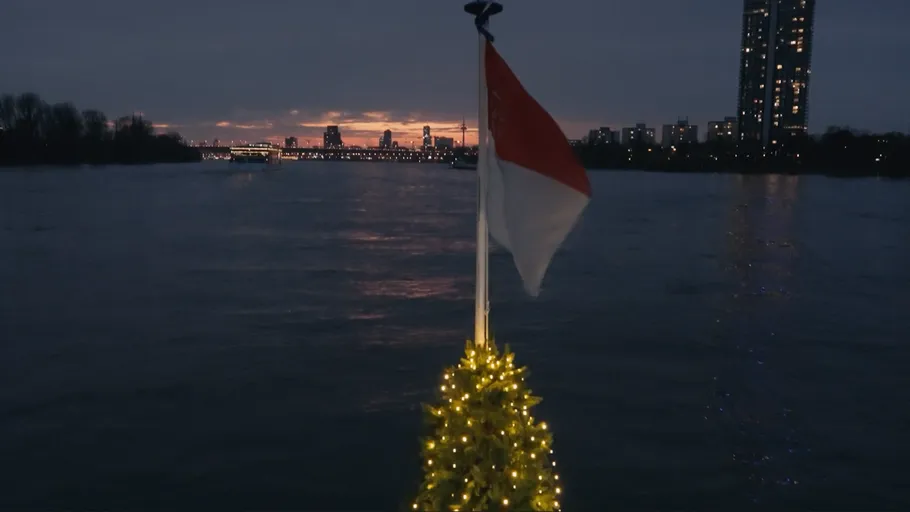 Flag and lights on boat with sunset.
