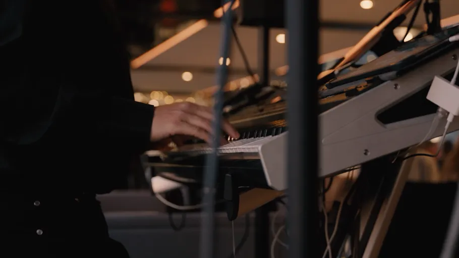 Person spielt Keyboard in schummriger Umgebung.