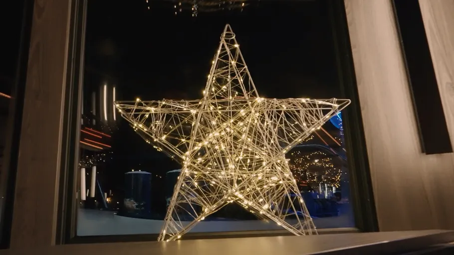 Beleuchteter Stern im Fenster bei Nacht.