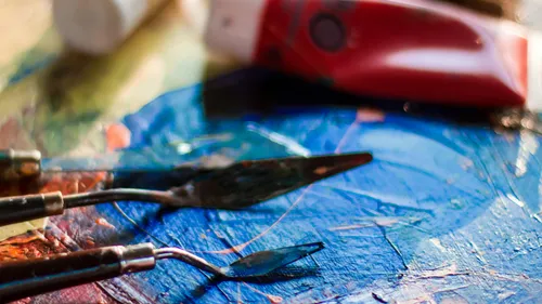 Palette knives on colorful painted canvas.