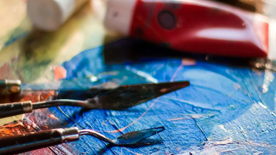 Palette knives on colorful painted canvas.