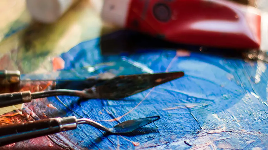Palette knives on colorful painted canvas.