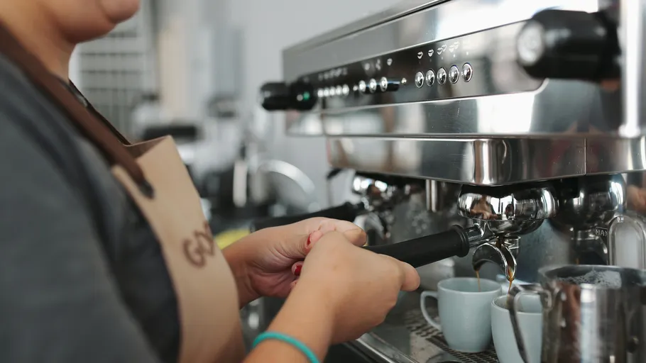 Barista making coffee with an espresso machine.