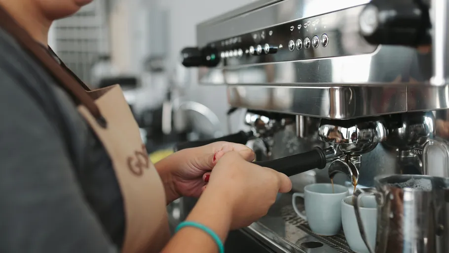 Barista making coffee using espresso machine.