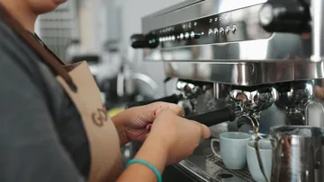 Barista benutzt Espressomaschine im Café.