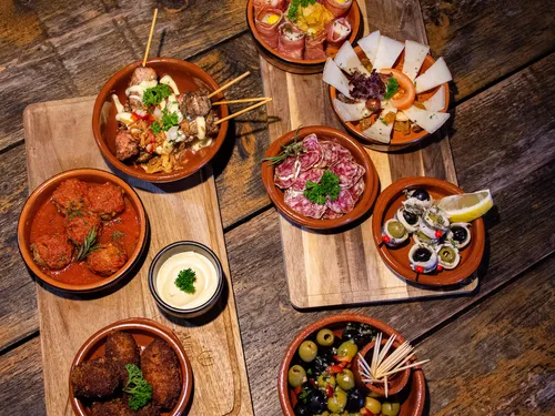Verschiedene Tapas auf Holzplatten, appetitlich angerichtet.