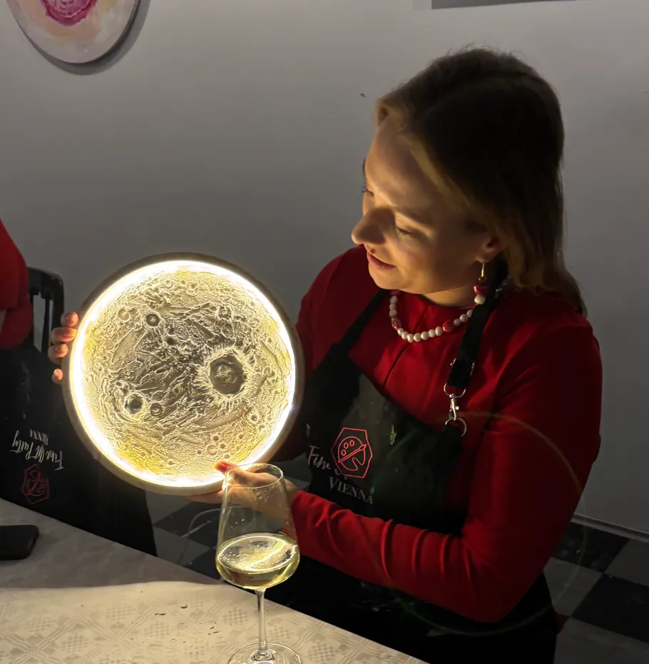 Frau hält leuchtende mondförmige Lampe drinnen.