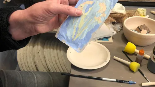 Hand hält bemaltes Papier im Kunststudio.