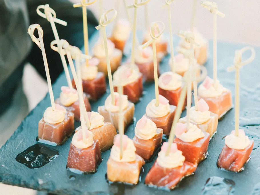 Tart topped appetizers served on black stone.