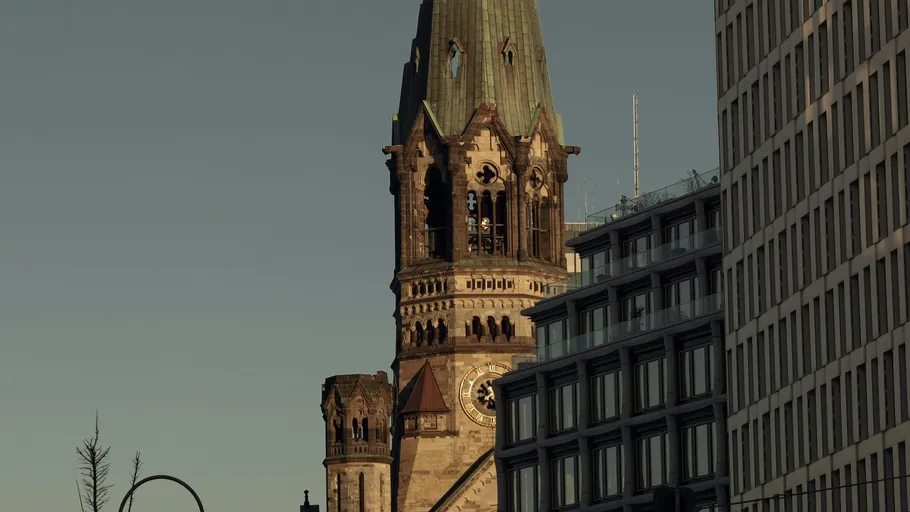 Church tower surrounded by modern buildings.