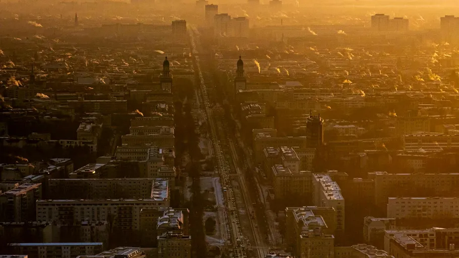 City skyline at sunset with glowing streets.
