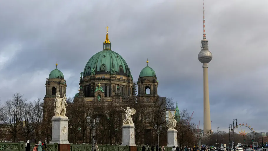 Cathedral and tower in Berlin with cloudy sky.