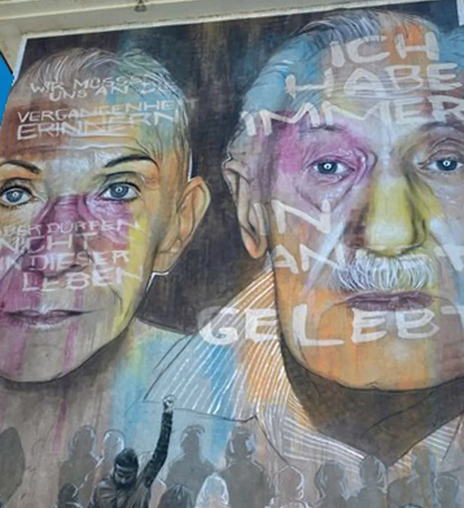 Two faces with text on colorful mural.