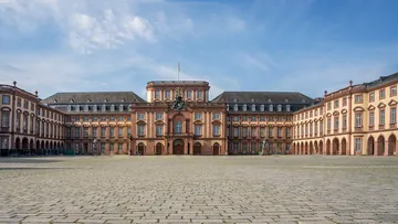 Historic palace with clock under blue sky.