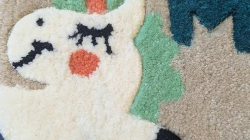 Abstrakter, bunter Teppich mit Tiergesicht.