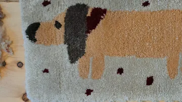 Cartoonhund-Illustration auf strukturiertem Teppich.