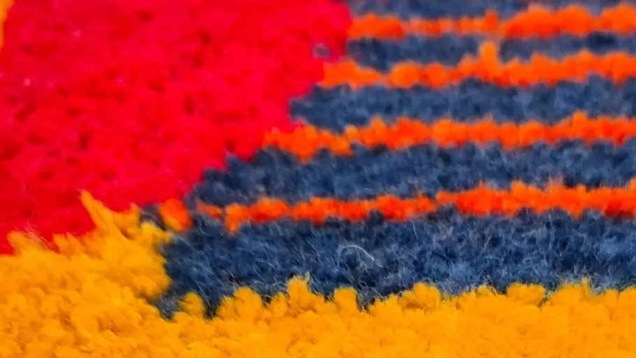 Colorful textured fabric with red, blue, orange.