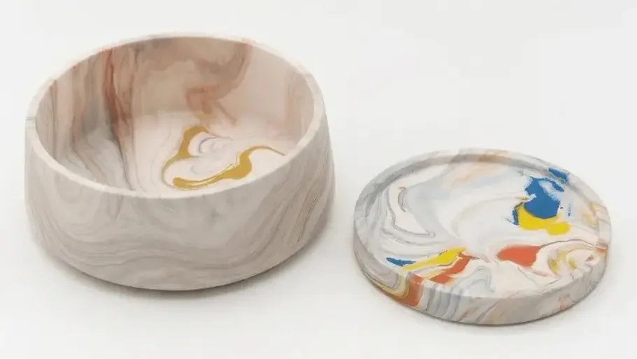 Marble-patterned bowl and lid on white background.