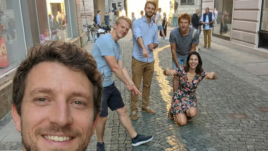 Gruppe von fünf Freunden posiert auf einer Straße.